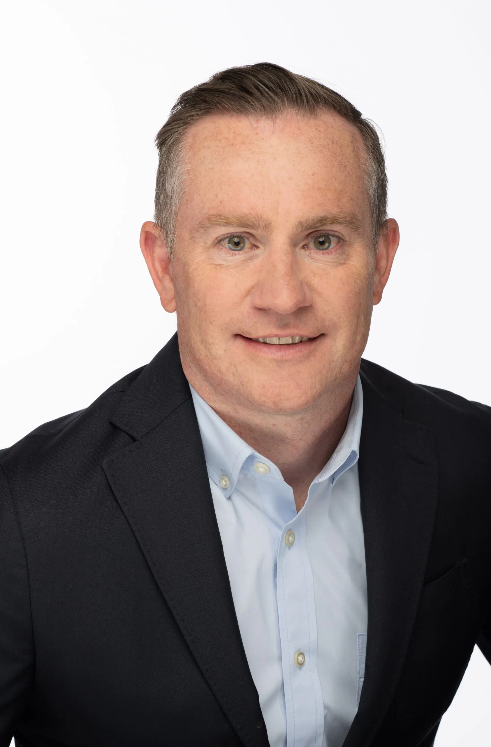 A head shot of a man wearing a dark suit and light blue shirt.